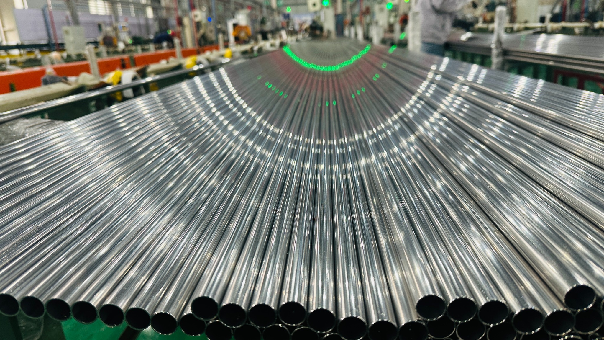 Bright polished stainless steel tubes aligned on a manufacturing line