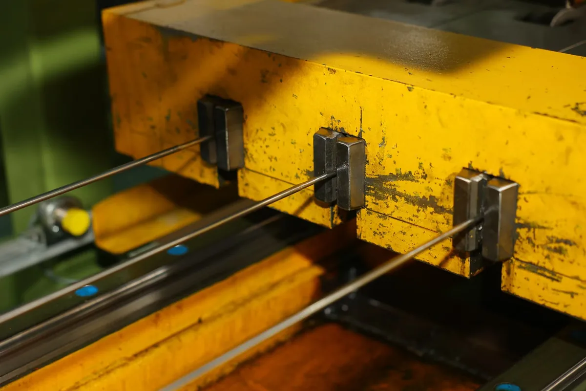 Metal tubes being drawn through dies in the workshop